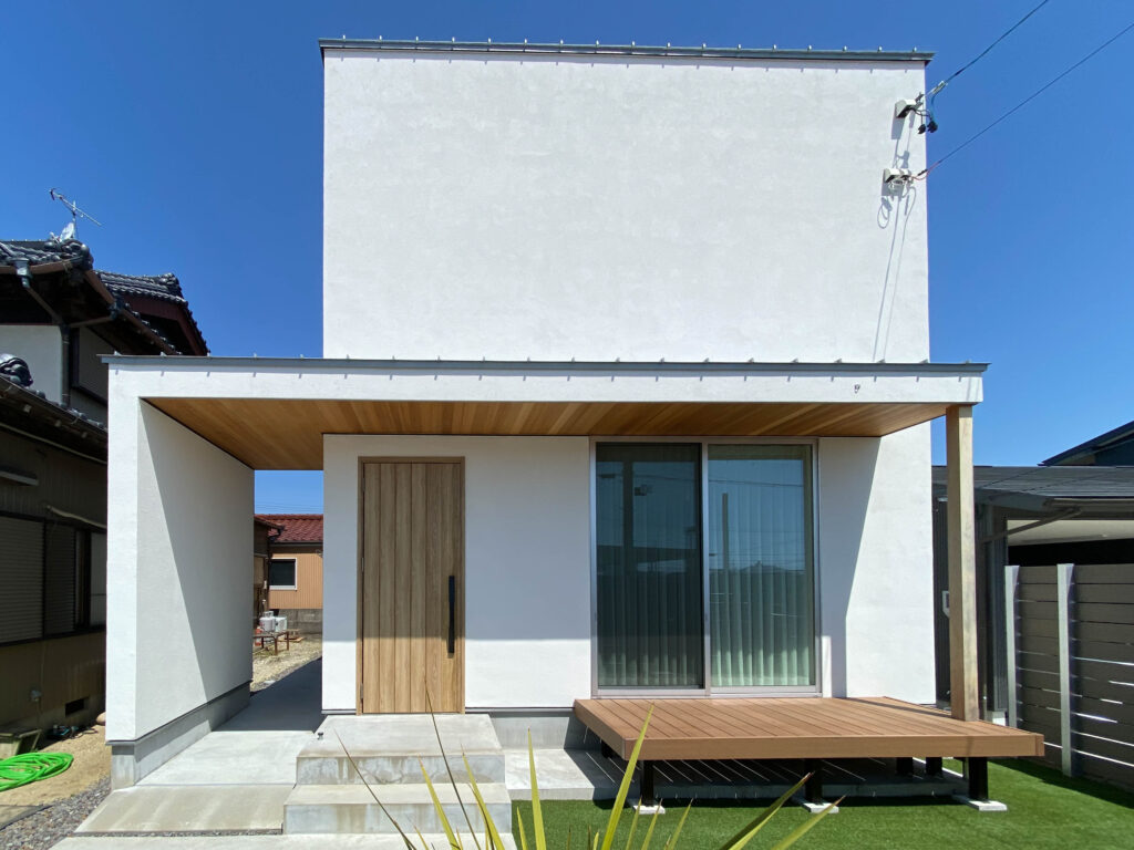 大きなひさしと濡れ縁が印象的な白の堅牢な住宅