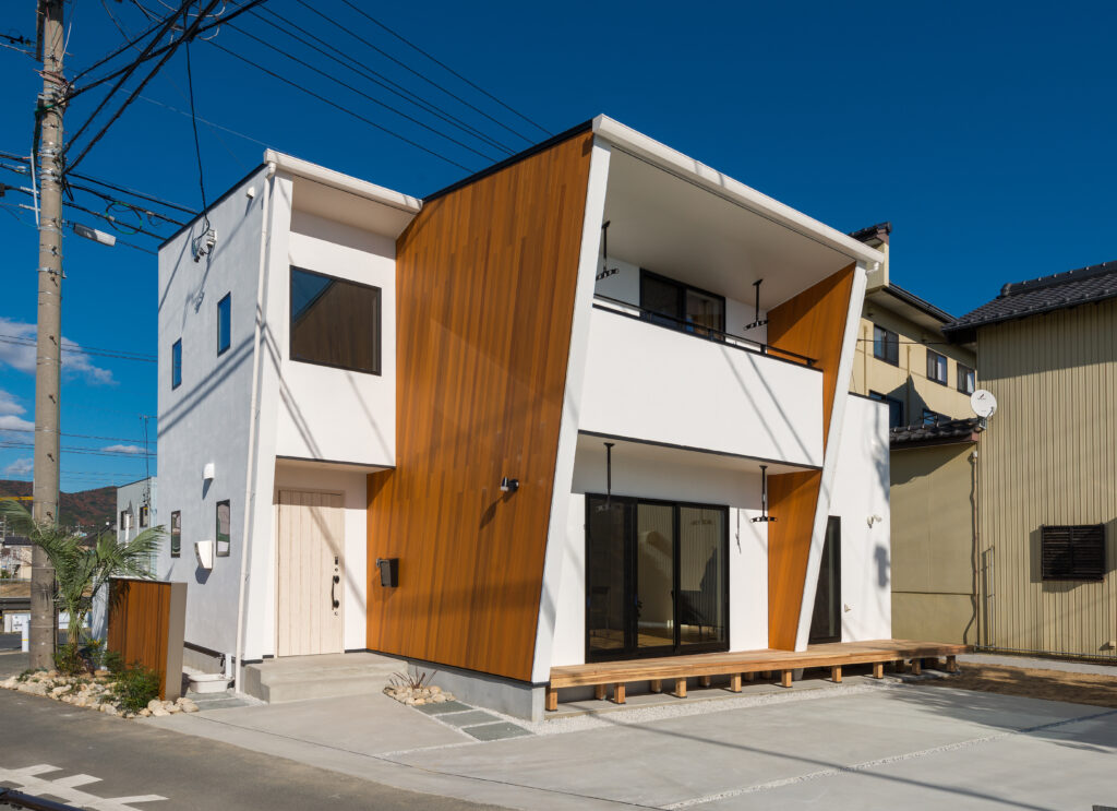 木目の壁と白い塗り壁のコントラストが印象的な二階建てのお家