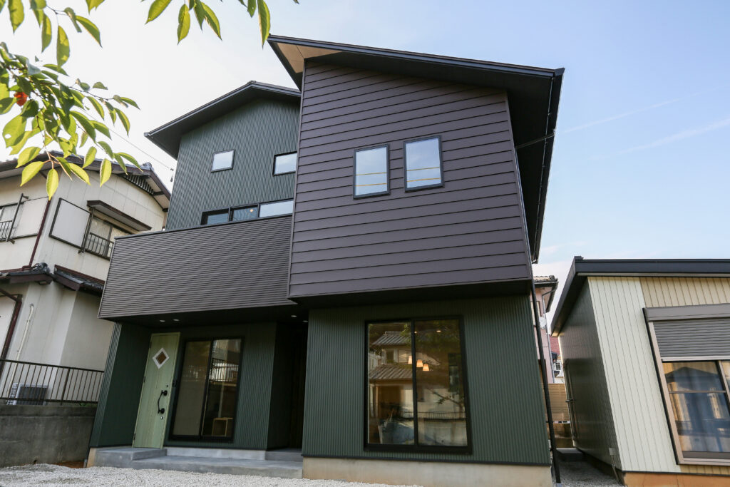 グリーンの壁が印象的な二階建てのお家