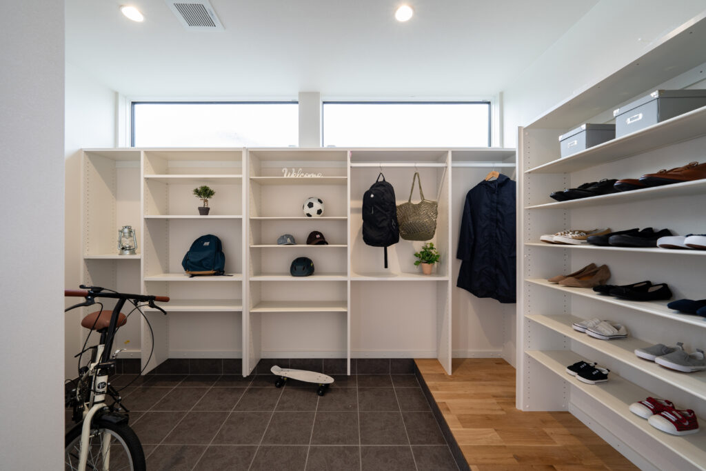 広い玄関土間収納。靴、自転車、リュック、上着などが収納されている。